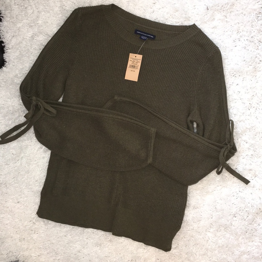 Green sweater w slit/ tied sleeve detail.